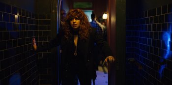 Movie still from “Russian Doll” (2019), created by Natasha Lyonne – A woman with red hair standing in a doorway; Medium shot, Over the shoulder angle