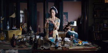 Movie still from “Russian Doll” (2019), created by Natasha Lyonne – A woman sitting in front of a messy table; Medium shot, High angle