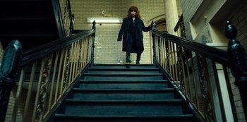 Movie still from “Russian Doll” (2019), created by Natasha Lyonne – A woman with red hair walking down a set of stairs; Wide shot, Low angle