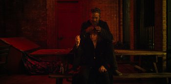 Movie still from “Russian Doll” (2019), created by Natasha Lyonne – A man and a woman sitting on top of a wooden bench; Medium shot, Over the shoulder angle