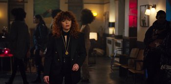 Movie still from “Russian Doll” (2019), created by Natasha Lyonne – A woman in a black jacket and a gold necklace; Medium shot, Over the shoulder angle