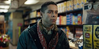 Movie still from “Russian Doll” (2019), created by Natasha Lyonne – A young man wearing a scarf in a grocery store; Close Up shot, Over the shoulder angle