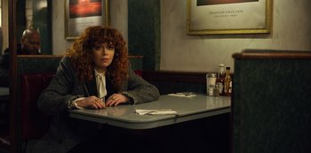 Movie still from “Russian Doll” (2019), created by Natasha Lyonne – A woman sitting at a table in a restaurant; Medium shot, Over the shoulder angle