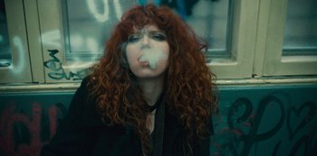 Movie still from “Russian Doll” (2019), created by Natasha Lyonne – A woman with red hair is smoking a cigarette; Close Up shot, Low angle
