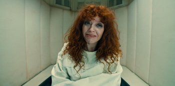 Movie still from “Russian Doll” (2019), created by Natasha Lyonne – A woman with red curly hair sitting in a chair; Close Up shot, High angle