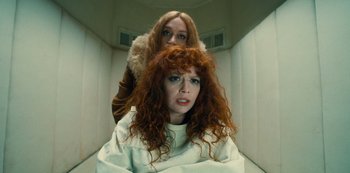 Movie still from “Russian Doll” (2019), created by Natasha Lyonne – A woman with red hair is sitting on a woman's shoulders; Close Up shot, High angle