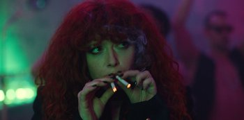 Movie still from “Russian Doll” (2019), created by Natasha Lyonne – A woman with red hair is smoking a cigarette; Close Up shot, Over the shoulder angle