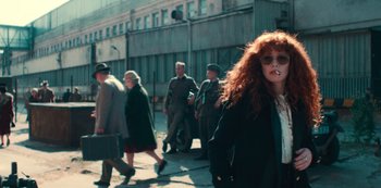 Movie still from “Russian Doll” (2019), created by Natasha Lyonne – A group of people walking down a street; Medium shot, Low angle
