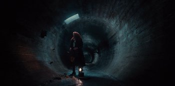 Movie still from “Russian Doll” (2019), created by Natasha Lyonne – A person standing inside of an underground tunnel; Wide shot, High angle
