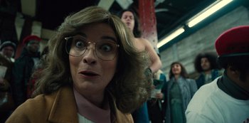 Movie still from “Russian Doll” (2019), created by Natasha Lyonne – A woman wearing glasses and a brown jacket is in a train; Close Up shot, Low angle