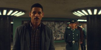 Movie still from “Russian Doll” (2019), created by Natasha Lyonne – A man in a jacket standing next to another man in a uniform; Medium shot, Low angle