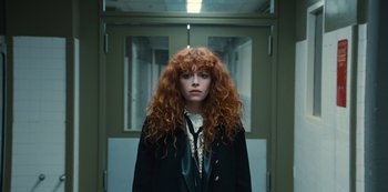 Movie still from “Russian Doll” (2019), created by Natasha Lyonne – A woman with red curly hair standing in front of a door; Medium shot, Low angle