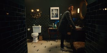 Movie still from “Russian Doll” (2019), created by Natasha Lyonne – A man standing in front of a sink in a bathroom; Wide shot, High angle