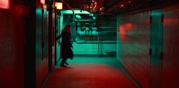 Movie still from “Russian Doll” (2019), created by Natasha Lyonne – A woman walking down a hallway in a building at night; Extreme Wide shot, High angle