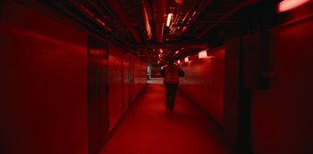 Movie still from “Russian Doll” (2019), created by Natasha Lyonne – A person walking down a hallway in a building; Extreme Wide shot, High angle