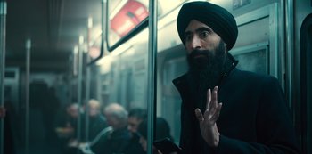Movie still from “Russian Doll” (2019), created by Natasha Lyonne – A man with a beard is riding on a subway train; Medium shot, Over the shoulder angle