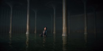 Movie still from “Russian Doll” (2019), created by Natasha Lyonne – A person in a body of water surrounded by pillars; Extreme Wide shot, High angle
