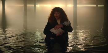 Movie still from “Russian Doll” (2019), created by Natasha Lyonne – A woman holding a white duck in a body of water; Medium shot, High angle