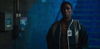 Movie still from “Russian Doll” (2019), created by Natasha Lyonne – A man with a badge on his neck standing next to a wall; Close Up shot, Over the shoulder angle