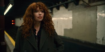Movie still from “Russian Doll” (2019), created by Natasha Lyonne – A woman with long red curly hair standing in front of a wall; Close Up shot, Low angle