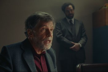 Movie still from “Argentina, 1985” (2022), directed by Santiago Mitre – An older man wearing a suit and tie next to a younger man; Medium shot, Over the shoulder angle