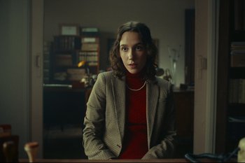 Movie still from “Argentina, 1985” (2022), directed by Santiago Mitre – A woman wearing a suit and a red sweater; Medium shot, Low angle