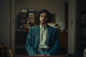 Movie still from “Argentina, 1985” (2022), directed by Santiago Mitre – A man in a blue jacket is standing in a room; Medium shot, Low angle