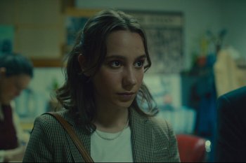 Movie still from “Argentina, 1985” (2022), directed by Santiago Mitre – A young woman is looking into the distance; Close Up shot, Over the shoulder angle