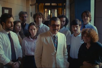 Movie still from “Argentina, 1985” (2022), directed by Santiago Mitre – A group of men and women standing in front of a building; Medium shot, High angle