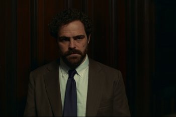 Movie still from “Argentina, 1985” (2022), directed by Santiago Mitre – A man in a brown suit and a purple tie; Close Up shot, Low angle