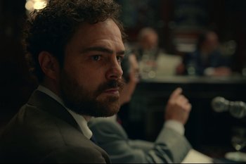 Movie still from “Argentina, 1985” (2022), directed by Santiago Mitre – A person wearing a suit and tie; Close Up shot, Low angle