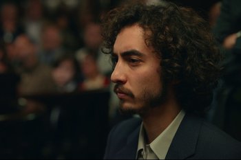 Movie still from “Argentina, 1985” (2022), directed by Santiago Mitre – A person wearing a suit and tie; Close Up shot, High angle