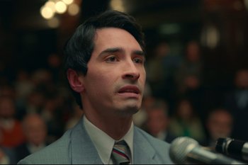 Movie still from “Argentina, 1985” (2022), directed by Santiago Mitre – A man wearing a suit and tie in front of a microphone; Close Up shot, Low angle