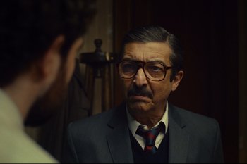 Movie still from “Argentina, 1985” (2022), directed by Santiago Mitre – An older man wearing a suit and tie looking into a mirror; Close Up shot, Over the shoulder angle