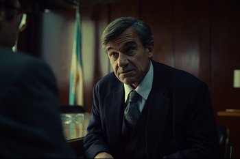 Movie still from “Argentina, 1985” (2022), directed by Santiago Mitre – A man in a suit and tie sitting at a table; Close Up shot, Over the shoulder angle