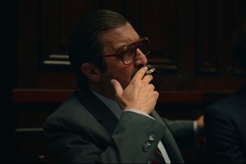 Movie still from “Argentina, 1985” (2022), directed by Santiago Mitre – A man in a suit and tie drinking a glass of wine; Close Up shot, Low angle