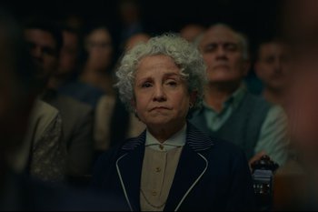 Movie still from “Argentina, 1985” (2022), directed by Santiago Mitre – An older woman with white curly hair is looking at the camera; Close Up shot, High angle
