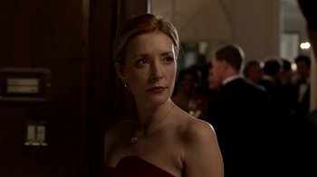 Movie still from “Salvation” (2017), created by Elizabeth Kruger – A woman in a red dress is standing in a room; Close Up shot, Over the shoulder angle