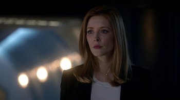 Movie still from “Salvation” (2017), created by Elizabeth Kruger – A woman in a black jacket and white shirt looking to her left; Close Up shot, Low angle