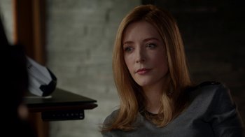 Movie still from “Salvation” (2017), created by Elizabeth Kruger – A woman sitting in front of a brick wall; Close Up shot, Over the shoulder angle