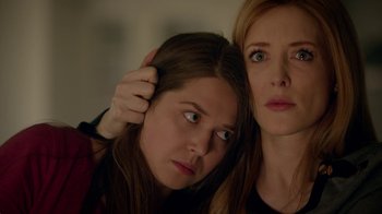 Movie still from “Salvation” (2017), created by Elizabeth Kruger – A woman is holding her hair next to another woman's face; Close Up shot, Low angle