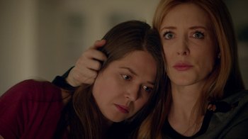 Movie still from “Salvation” (2017), created by Elizabeth Kruger – Two women posing for a picture with one of them touching the other's hair; Close Up shot, Low angle