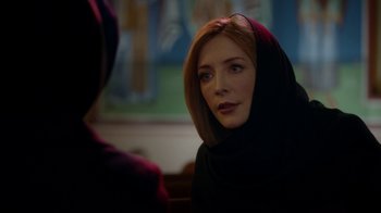 Movie still from “Salvation” (2017), created by Elizabeth Kruger – A woman wearing a black headscarf looking at a mirror; Close Up shot, Over the shoulder angle