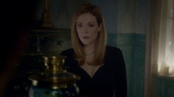 Movie still from “Salvation” (2017), created by Elizabeth Kruger – A woman in a black dress looking at the camera; Medium shot, Over the shoulder angle