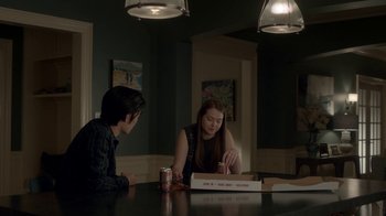 Movie still from “Salvation” (2017), created by Elizabeth Kruger – Two people sitting at a table with a box of pizza; Medium shot, Over the shoulder angle
