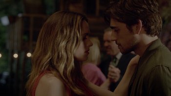 Movie still from “Salvation” (2017), created by Elizabeth Kruger – A man and a woman are looking at each other in front of other people; Close Up shot, Over the shoulder angle