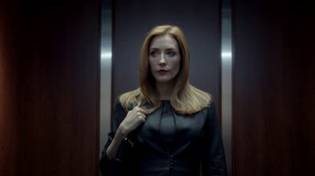 Movie still from “Salvation” (2017), created by Elizabeth Kruger – A woman standing in front of an elevator; Medium shot, Low angle