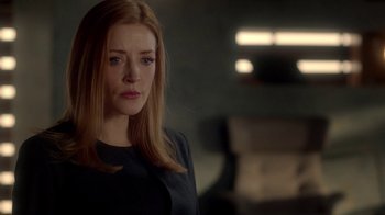 Movie still from “Salvation” (2017), created by Elizabeth Kruger – A woman with long blonde hair standing in front of a wall; Close Up shot, Over the shoulder angle