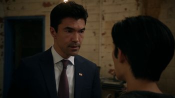 Movie still from “Salvation” (2017), created by Elizabeth Kruger – A man wearing a suit and tie talking to another man wearing a tie; Close Up shot, Over the shoulder angle