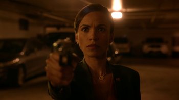 Movie still from “Salvation” (2017), created by Elizabeth Kruger – A woman holding a gun in a parking garage; Close Up shot, High angle